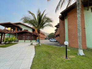 a street with palm trees next to a building at Pé na Areia na Praia das Toninhas - Villagio 24 Porto Feliz in Ubatuba