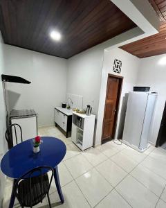 a kitchen with a blue table and a refrigerator at Edícula in Porto Velho