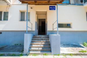 ein Gebäude mit einer Treppe, die zu einer Tür führt in der Unterkunft Relaxveld Galaxy in Curtea de Argeş