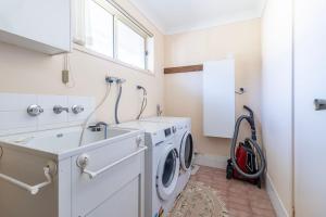 a laundry room with a washing machine and a sink at Berrara Breeze in Berrara