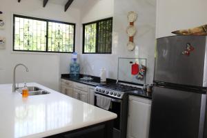 Una cocina con frigorífico de acero inoxidable y fregadero. en CAJOMA Villa, en San Ignacio