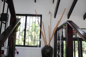 Un jarrón con palos junto a una ventana. en CAJOMA Villa, en San Ignacio