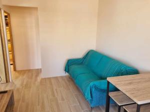 a green couch in a room with a table at Ti kaz Palmiste in Saint-Philippe