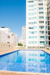 a swimming pool in front of a tall building at Reserva de la Sierra in Santa Marta