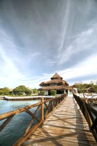 a wooden bridge leading to a resort on the water at El Embrujo Tintipan in Tintipan Island