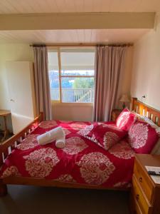 una camera con letto rosso e finestra di Ellstanmor Guesthouse Cooma a Cooma