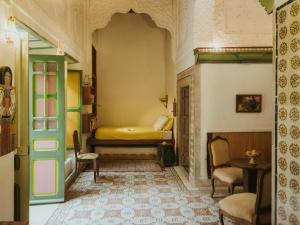 a bedroom with a bed and a table and chairs at La Chambre bleue in Tunis