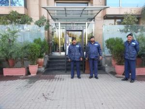 a group of three men standing in front of a door at Hotel Crown Plaza Islamabad in Islamabad
