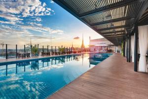a swimming pool on a building with a sunset in the background at NagaWorld Hotel & Entertainment Complex in Phnom Penh