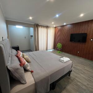 a bedroom with a large bed and a flat screen tv at Hotel Campestre Casa Laredo in Chao +2 photos