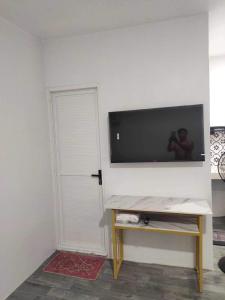 a room with a tv on a wall with a door at Pike Guest House 2 in Dagupan