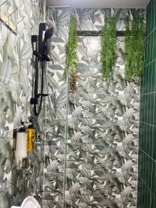 a bathroom with a shower with plants on the wall at DonMueang station hotel in Ban Don Muang (1) +73 photos