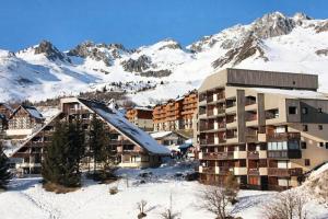 un hotel nella neve con montagne sullo sfondo di Studio 4 Personnes Confort MAE-9521 a Saint-François-Longchamp