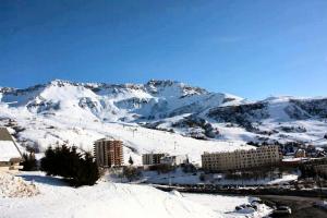 una montagna innevata con una città e edifici di Studio 4 Personnes Confort MAE-9521 a Saint-François-Longchamp