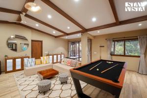 a living room with a pool table in it at StayVista at Casa Chalora with Pool, BBQ, Games Room in Candolim
