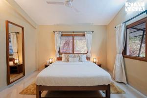 a bedroom with a bed and a window at StayVista at Casa Chalora with Pool, BBQ, Games Room in Candolim +22 photos