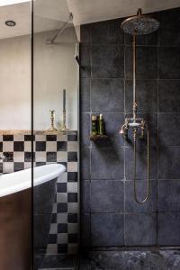 a bathroom with a shower and a tub and a sink at La Petite Foret Cottage In Brussels Countryside in Asse