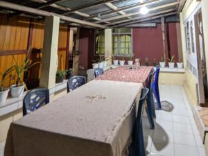 a room with a long table and chairs and plants at Bunaken GuestHouse in Bunaken