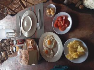 a table with plates of breakfast food on it at Bunaken GuestHouse in Bunaken +1 photo