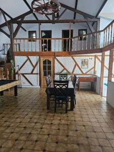 a large room with a table and chairs and a staircase at La bergerie in La Bruyère