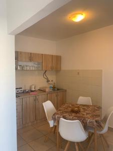 een keuken met een tafel en een aantal witte stoelen bij Waterfront Apartments in Tisno
