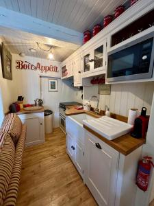a kitchen with white cabinets and a sink at La Petite Madeleine is a Charming 2 Bedroom Pet Friendly Gite situated on Dinan Port in Dinan