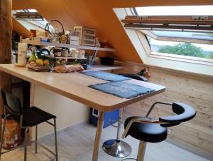 a kitchen with a large wooden table and two stools at Le doux refuge bercéen au calme de sa campagne près circuit Mans Sud, grand lit avec berceau et possibilité lit pliant en rajout in Marigné-Laillé +11 photos