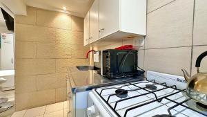 a kitchen with a stove and a microwave at Departamentos Arrayanes in El Bolsón