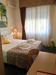 um quarto de hotel com duas camas e uma mesa em Hotel Scandinavia em Marina di Massa mais 31 fotografias