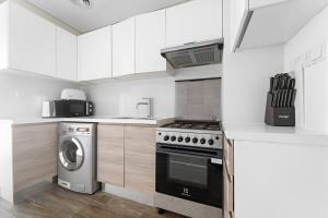 una cucina con fornelli e lavatrice di FIRST CLASS Studio Rustic Charm in SOL BAY a Dubai