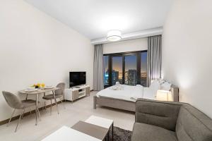 una camera con letto, tavolo e divano di FIRST CLASS Studio Rustic Charm in SOL BAY a Dubai