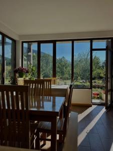 a dining room with a table and chairs and a large window at Beko’s garden Inn in Mestia +45 photos