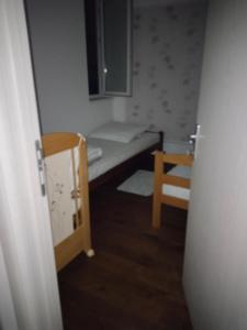 ヴルシャツにあるSandra apartmani 4のベッドと椅子のある小さな部屋