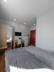 a bedroom with a bed and a desk and a television at Sweet studio with all amenities in Batumi