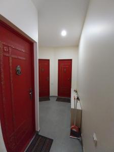 a hallway with three red doors in a building at Sweet studio with all amenities in Batumi