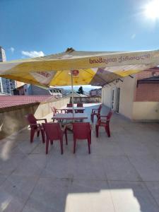 a patio with tables and chairs and a large umbrella at Sweet studio with all amenities in Batumi