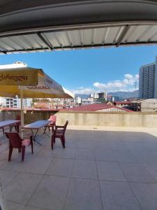 a patio with a table and chairs and an umbrella at Sweet studio with all amenities in Batumi