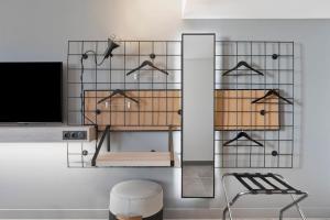 a room with a tv and a shelf with hangers at Moxy La Ciotat in La Ciotat