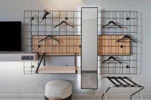 a room with a tv and a chair and a mirror at Moxy La Ciotat in La Ciotat
