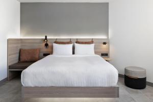 a bedroom with a large bed and a chair at Moxy La Ciotat in La Ciotat