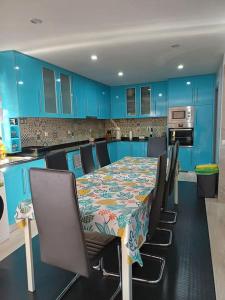 a kitchen with a table with chairs and blue cabinets at Special Room Sofia's Happy House- Almodôvar Ourique - Room 3 in Aldeia dos Fernandes