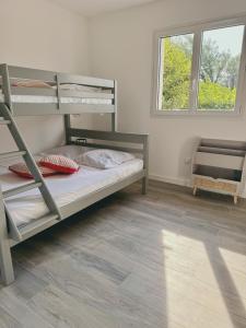 Un dormitorio con dos literas y una ventana. en Karzen, en Ghisonaccia