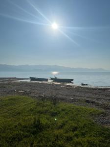 two boats sitting on the shore of a beach at Lake shkodra in Omarë