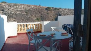 a patio with a table and chairs on a balcony at Xlendi Cozy Apartment in Xlendi