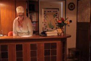 an older woman standing at a counter in a kitchen at Hotel Hubertus in Hannover