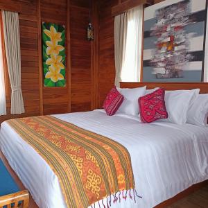 a bedroom with a white bed with red pillows at Otila Bali Villa in Uluwatu