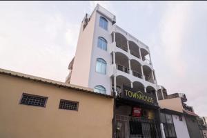 a tall white building with a sign on it at Hotel Townhouse in Rishīkesh