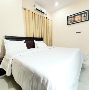 a bedroom with two white beds and a window at Hotel Townhouse in Rishīkesh