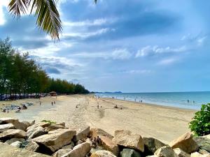 a beach with a bunch of people on it at Cozii Home Marang in Marang