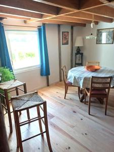 Un comedor con mesa y sillas y una ventana. en Maison en campagne style western, en Halluin